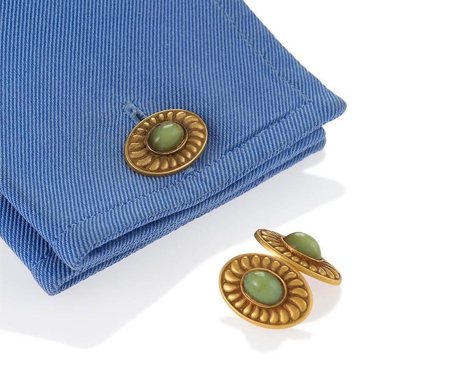 A pair of Arts & Crafts 18 karat gold cuff links with chrysoberyl by Pickslay & Co.. The cuff links have 4 bezel set oval chrysoberyl stones surrounded by gold swirl motif frames. The cuff links are double sided. Circa 1910. 

Pickslay & Co. was