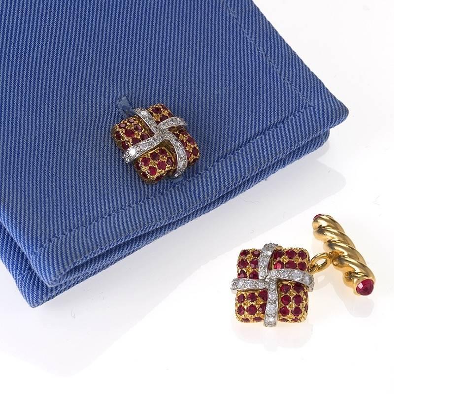 A pair of gold cuff links with diamonds and rubies by Verdura. The cuff links have 40 round-cut diamonds with an approximate total weight of .96 carats, and 84 round-cut rubies with an approximate total weight of 3.20 carats. The cuff links are