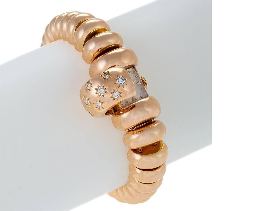 A Swiss Retro 18 karat rose gold bracelet covered watch with diamonds by Rolex. The hinged watch cover has 13 round-cut diamonds that are “serti étoilé” set and have an approximate total weight of .75 carats. The bracelet is composed of graduated
