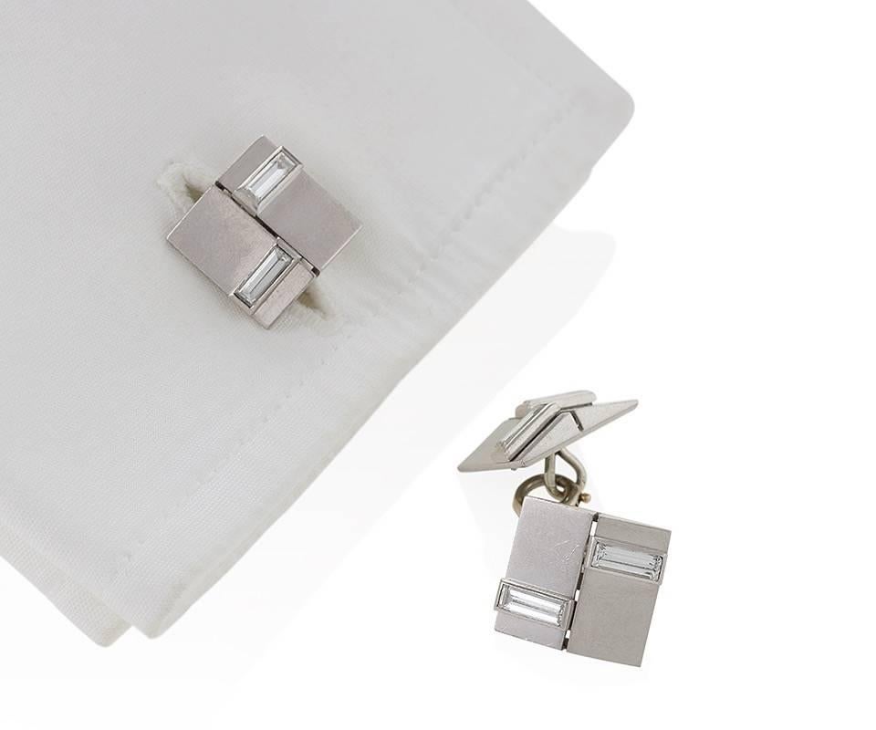A pair of French Art Deco platinum cuff links with diamonds by Van Cleef & Arpels. The cuff links have 8 baguette diamonds with an approximate total weight of .70 carats. The double sided cuff links are designed in a graphic Art Deco motif with
