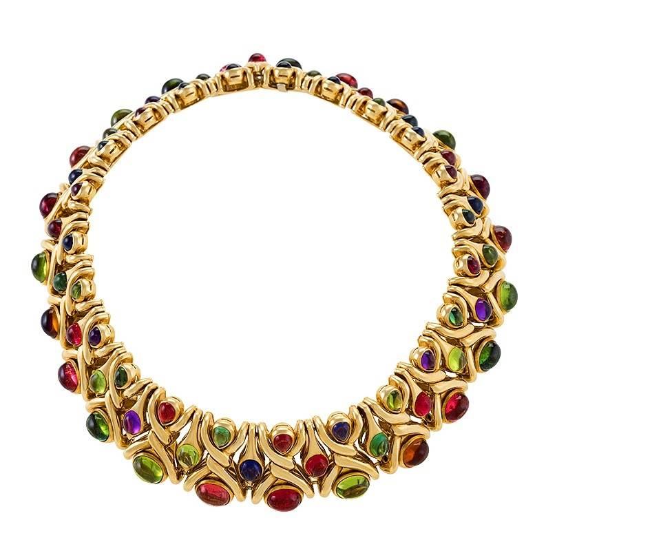 A late 20th Century 18 karat gold necklace with pink tourmalines, rubellites, peridots, citrines, amethysts, tourmalines and iolites by Bulgari. The necklace is composed of pairs of articulated polished gold links of overlapping ribbons spaced by 23