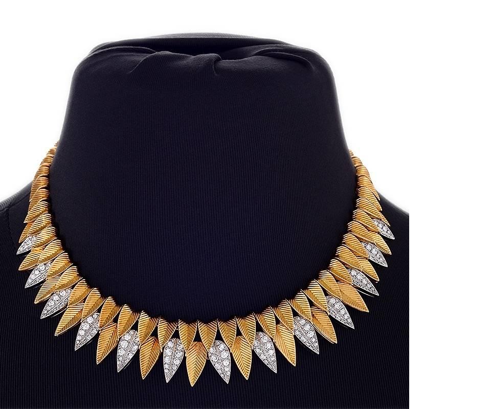 This Cartier necklace, in gold and diamonds, explores the interplay of light with textured, canted, and layered surfaces with a full set of hanging leaves that elegantly drape as fringe across the collarbone. Finely articulated, the ridged, gleaming