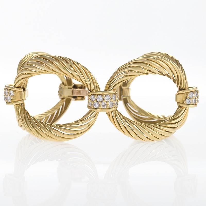 A French 18 karat gold bracelet with diamonds by Boucheron Paris. The bracelet has 40 round-cut diamonds with an approximate total weight of 5.00 carats. The 5 ribbed open oval links are connected with diamond pavé links. With original signed