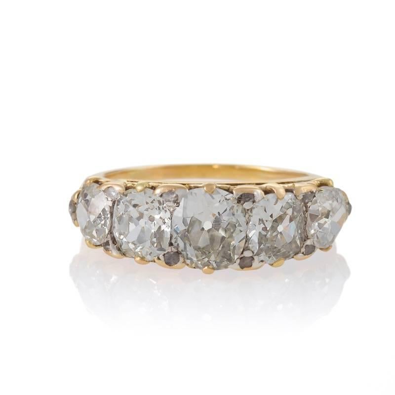 An Antique English 18 karat gold ring with diamonds. The ring has 5 old mine-cut diamonds with an approximate total weight of 5.30 carats, K/L color, SI clarity. The diamond center is approximately 1.60 carats, then descending diamonds each weighing