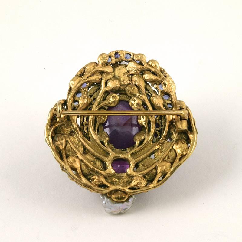 An American Art Nouveau 18 karat gold brooch with purple star sapphire, blue sapphire and pink sapphire by Louis Comfort Tiffany. The brooch centers on a cabochon purple star sapphire with an approximate weight of 30.00 carats, 40 Montana blue