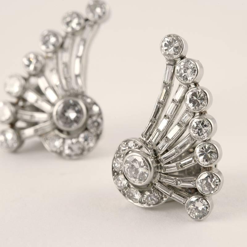 A pair of French Art Deco platinum earrings with diamonds. The earrings have 28 round-cut diamonds with an approximate total weight of 3.00 carats, and 38 baguette diamonds with an approximate total weight of 1.50 carats. The approximate total carat