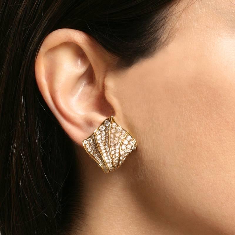 A pair of American Estate 18 karat gold and diamond earrings by Kurt Wayne, featuring a shell design with pavé-set round-cut diamonds with an approximate total weight of 4.00 carats, VS clarity, G/H color. Circa 1980's.

Signed, “KW”  