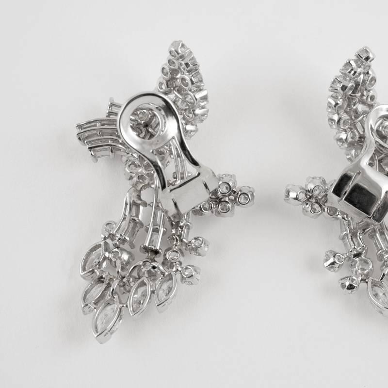 A pair of Mid-20th Century platinum earrings with round-, baguette- and marquise-cut diamonds. The earrings have 60 round-cut diamonds with an approximate total weight of 3.00 carats, 36 baguette-cut diamonds with an approximate total weight of 2.60