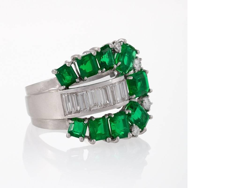 Ein Retro-Platinring mit Smaragden und Diamanten. Der Ring hat 9 Smaragde mit einem ungefähren Gesamtgewicht von 4,40 Karat, 4 runde Diamanten mit einem ungefähren Gesamtgewicht von 0,30 Karat und 8 Baguette-Diamanten mit einem ungefähren