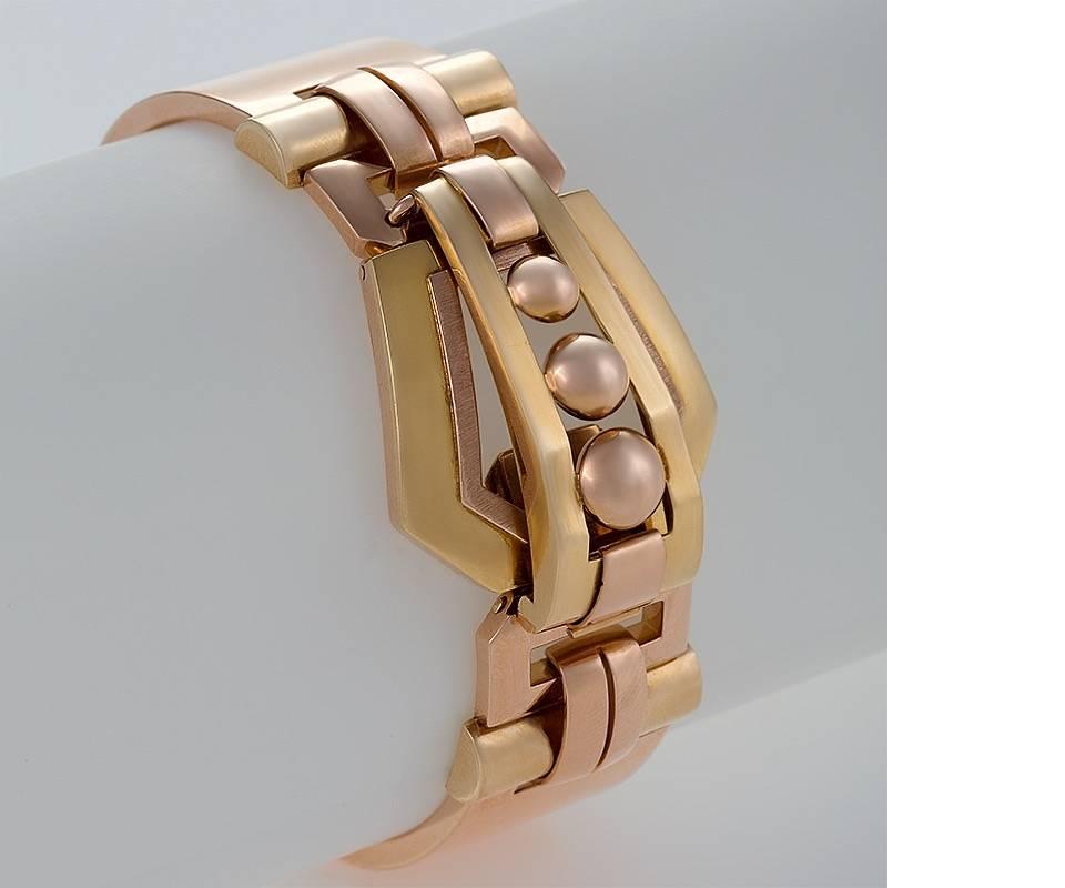 A Retro 18 karat gold bracelet. The bangle bracelet is composed of yellow and rose gold in a stylized buckle motif which forms the double clasp. The bracelet is center hinged. Circa 1940’s. 

Dimensions: Interior measurement 6-3/4”

(MG #16689)