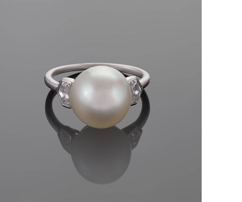 A French Art Deco platinum ring with a natural saltwater pearl and diamonds by Cartier. The ring has a natural saltwater pearl measuring  11.6 x 11.6 x 11.0 mm., and 2 kite shaped diamonds weighing approximately .50 carat.
Partial 256 French