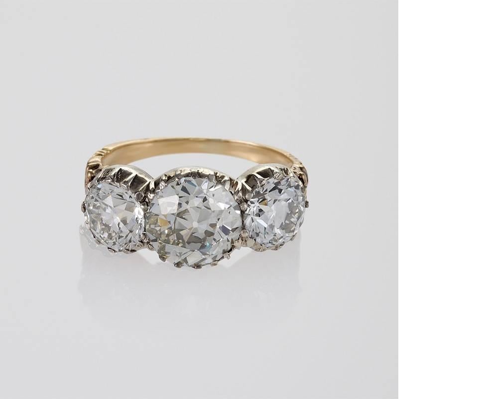 An Antique 18 karat gold and oxidized silver ring with diamonds. The ring has a center old European-cut diamond with an approximate total weight of 2.23 carats, K/L color, VS/SI clarity, and is flanked by 2 old European-cut diamonds with an