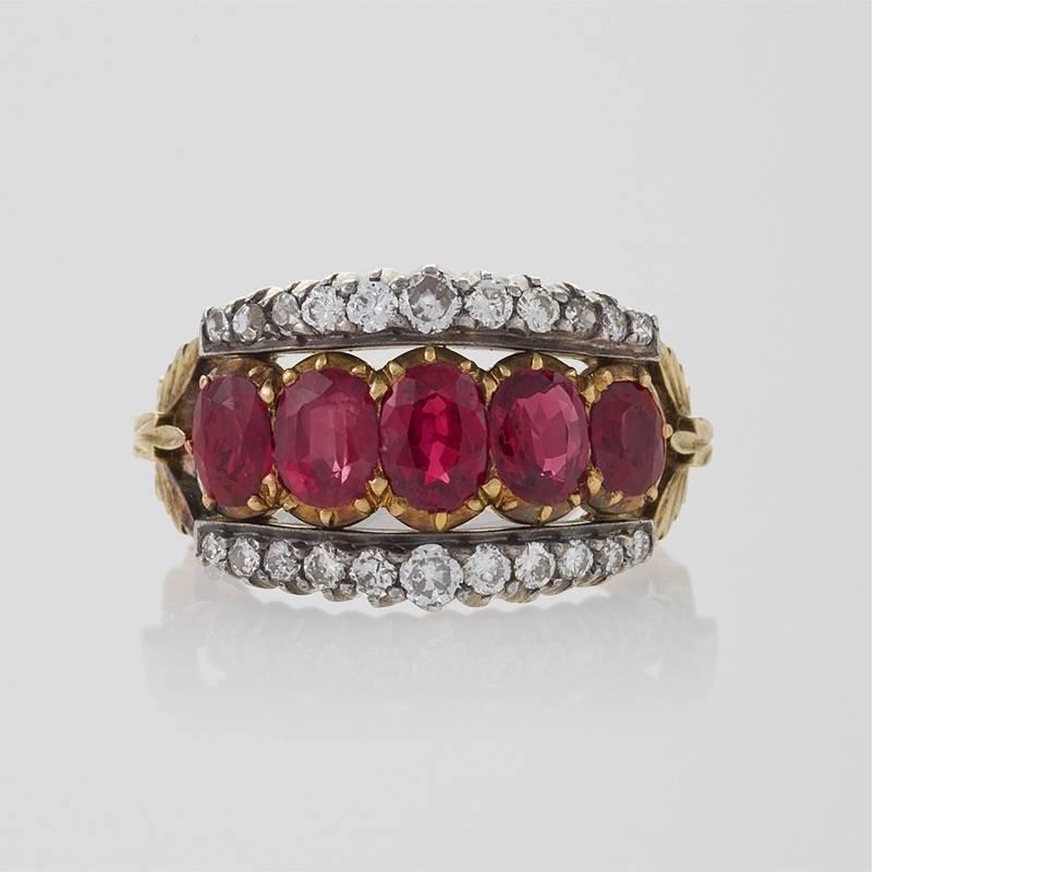 A French Antique 18 kt gold and oxidized silver ring with rubies and diamonds. The ring has 5 oval-cut rubies with an approximate total weight of 1.20 carats, and 22 round-cut diamonds with an approximate total weight of .60 carat. The center