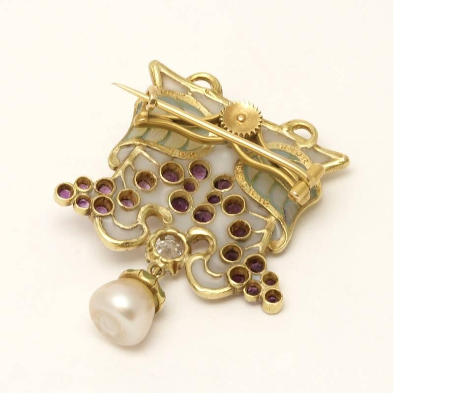 An Art Nouveau 18 karat gold and plique à jour brooch with diamond, amethysts and pearl by Louis Zorra. The brooch has an old mine-cut diamond with an approximate total weight of .65 carat, 21 round bezel-set amethysts with an approximate total