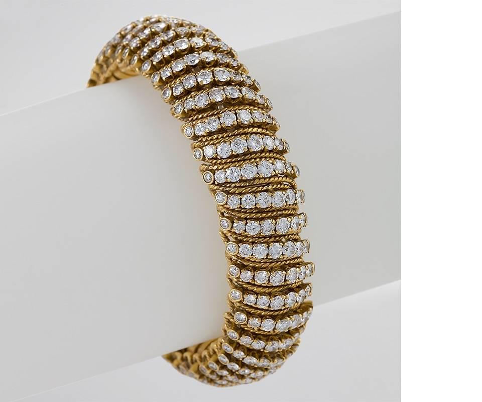 A French Mid-20th Century 18 karat gold bracelet with diamonds by Van Cleef & Arpels. The bracelet has 350 round-cut diamonds with an approximate total weight of 19.25 carats, F/G color, VS clarity. The bracelet is of bombé design, with alternating