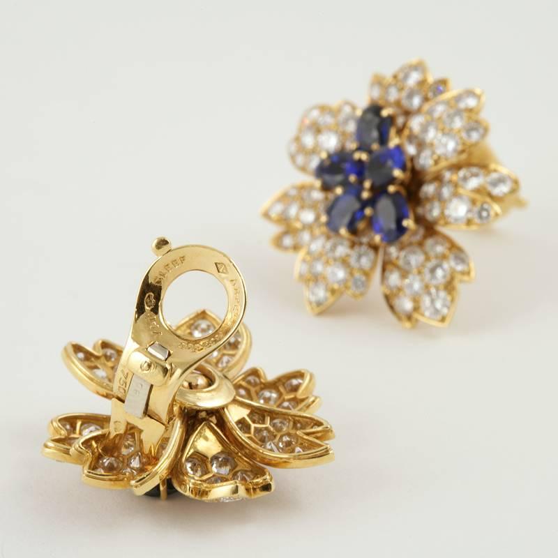 A pair of French Estate 18 karat gold earrings with diamonds and blue sapphires by Van Cleef & Arpels. The earrings have 144 round diamonds with an approximate total weight of 10.00 carats, F/G color, VS clarity, and 10 oval blue sapphires with an