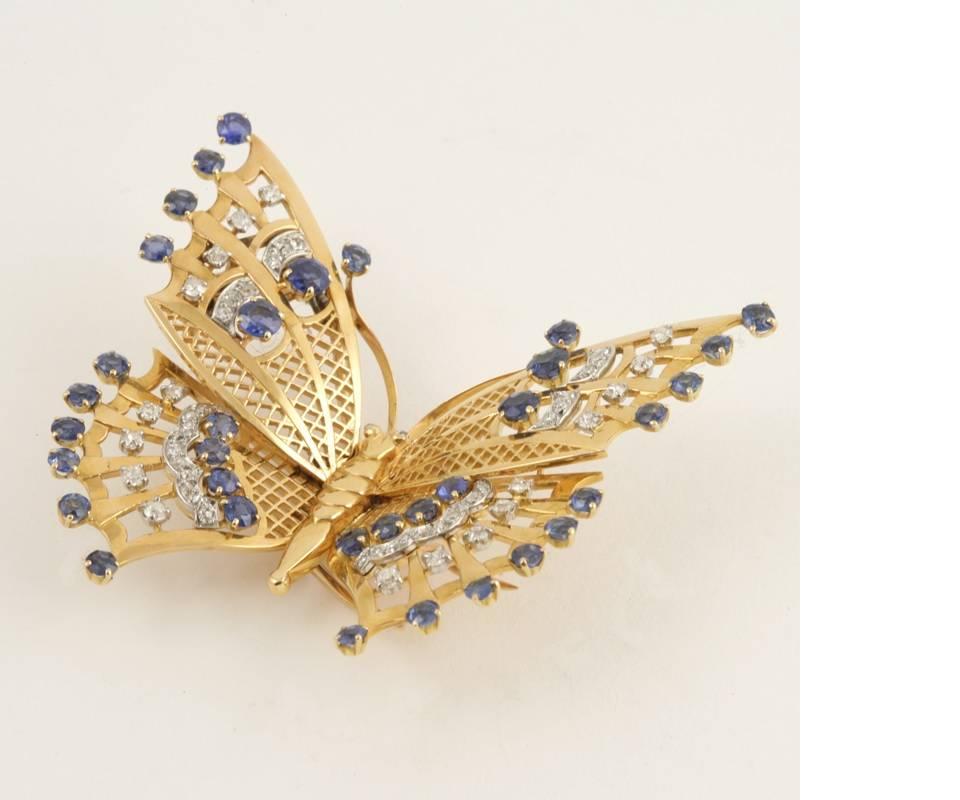 A French Art Deco 18 karat gold brooch with sapphires and diamonds by Mauboussin. The brooch has 34 round sapphires with an approximate total weight of 2.00 carats, and 54 old European-cut diamonds with an approximate total weight of 1.35 carats.