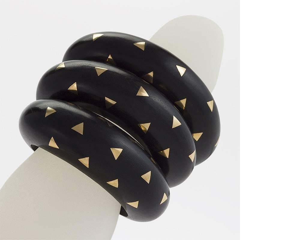 A set of three French Late-20th Century ebony cuffs with 18 karat gold accents by Van Cleef & Arpels. 
Van Cleef & Arpels have been designing and making wood jewelry since the 1920's.  Circa 1987-93.

Similar from the collection pictured in