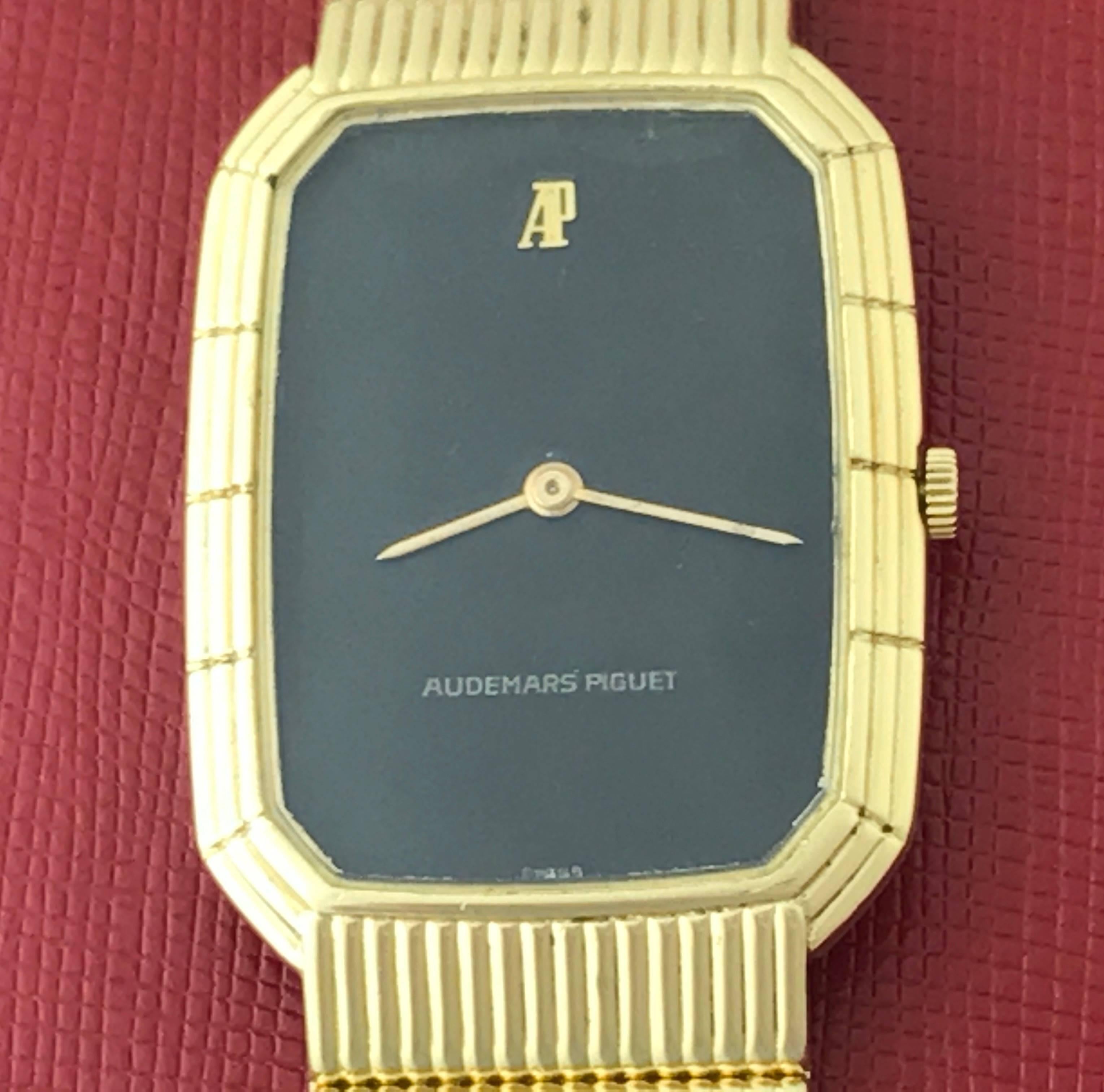 Beautiful Audemars Piguet pre-owned contemporary men's wrist watch. Manual wind watch with black dial and 18k yellow gold rectangular case measuring 27 by 42mm. Also featuring a stunning 18k yellow gold Audemars Piguet integrated bracelet. This