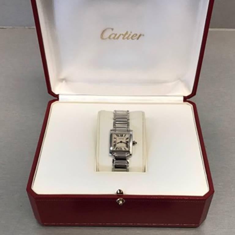 Like New Cartier Ladies Tank Francaise Model W50012S3. Quartz movement. 18k White Gold square style case measuring 20mm x 25mm. 18k White Gold Cartier Tank Francaise bracelet with deployant clasp. Silvered Dial with black Roman numerals. Certified