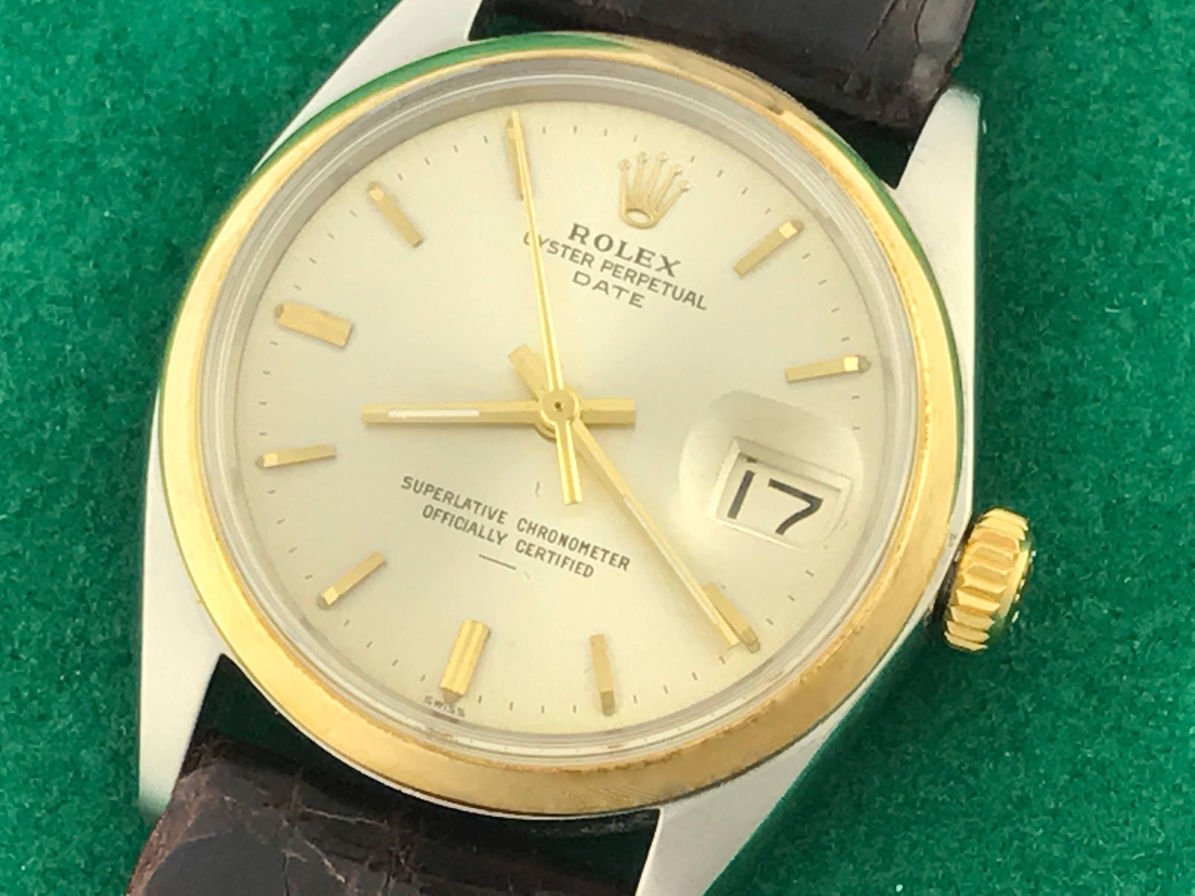 The Rolex Date Model 1500 pre-owned men's automatic wrist watch. Featuring an oyster silvered dial with yellow gold hour markers and stainless steel case with 14K yellow gold smooth bezel. Measures 34mm. Comes with a dark brown alligator strap, box,
