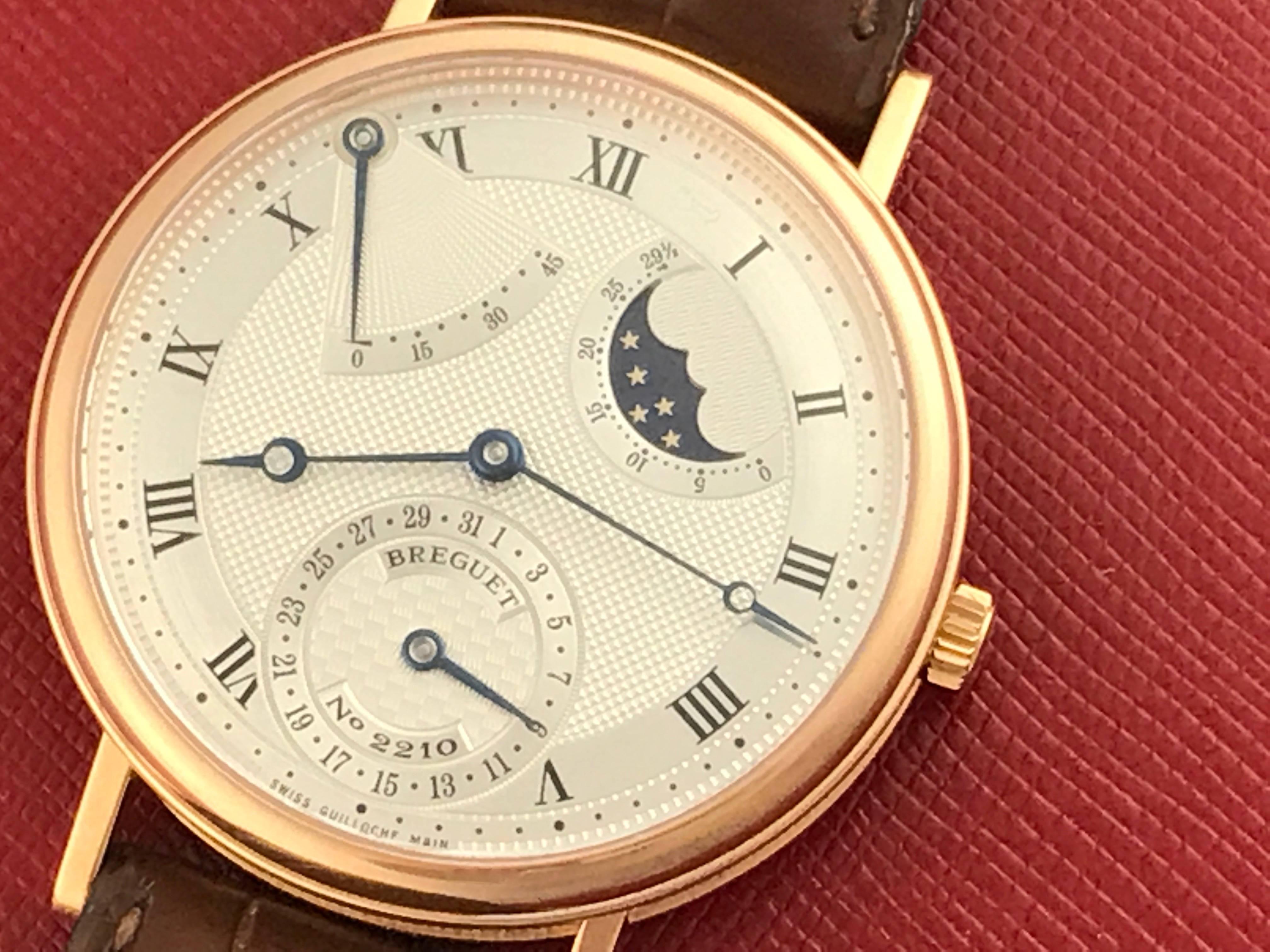 Breguet Classique Moon Phase Model 3137BR/11/986 pre-owned men's automatic wrist watch. Moonphase with Power Reserve Indicator and sweeping center seconds. Silvered Guilloche Dial with black Roman numerals. 18k Rose Gold round style case with