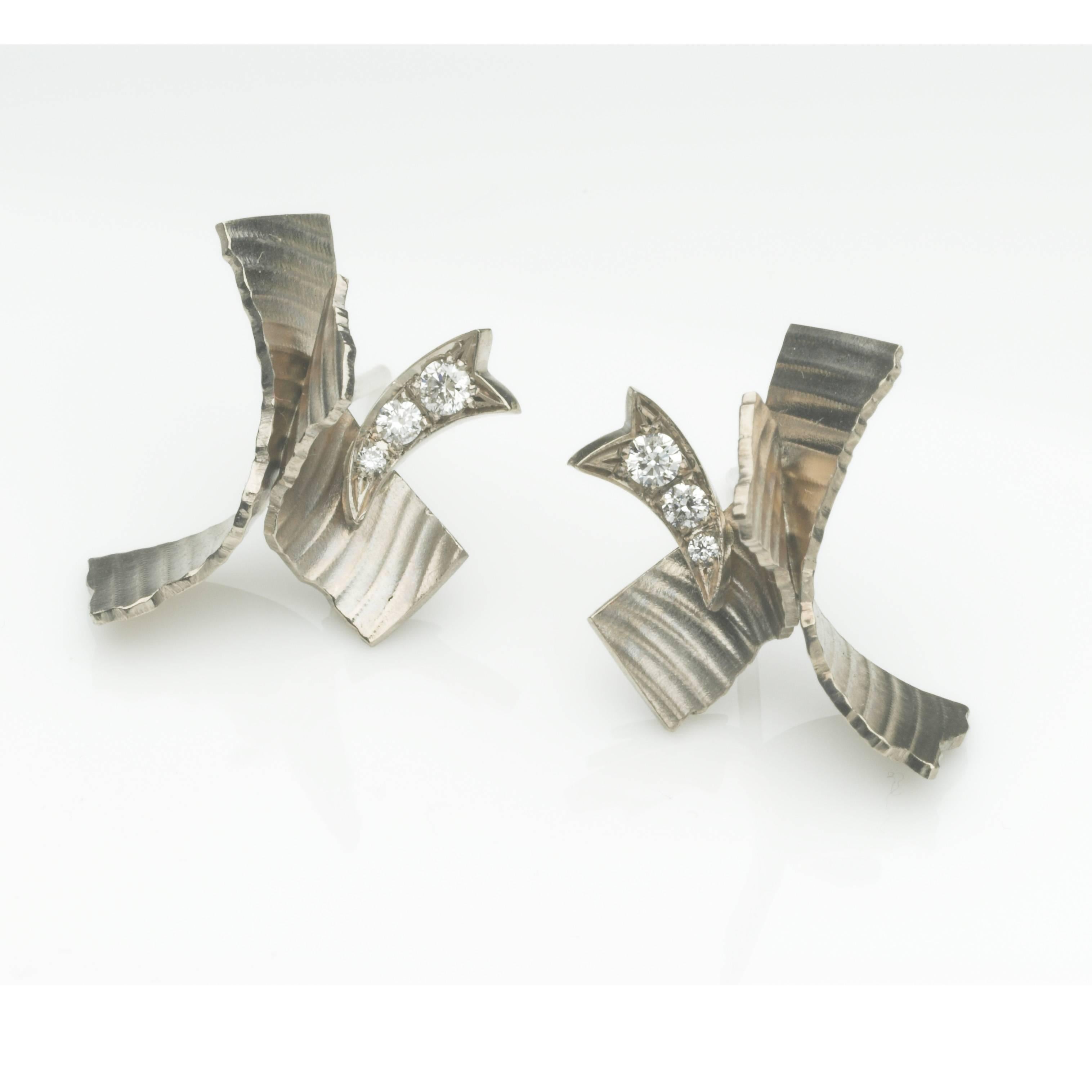 18ct white gold Mini Flutter earrings with a seductive ribbon texture, torn edges, and diamond flashes. The fittings are posts and scrolls.