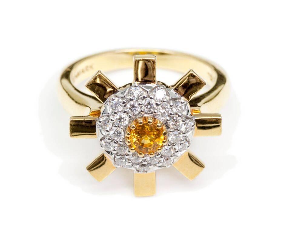 The Stenmark Sun Ray petite ring in 18 karat yellow gold, with a disc of 22 x 1.7 mm G colour VS1 diamonds encircling a 4 mm yellow sapphire, is the perfect engagement ring for an unconventional bride. The lustrous, highly-polished gold bars