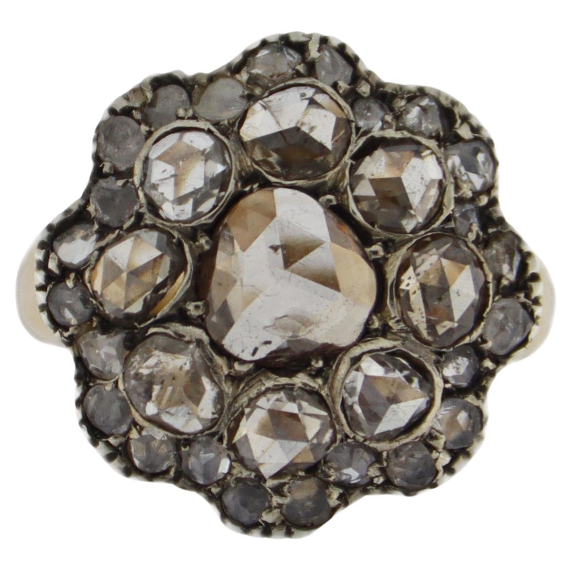 This captivating ring is a stunning fusion of craftsmanship and vintage-inspired design, crafted in a combination of 14kt yellow gold and 800 silver, evoking timeless elegance. The ring features a classic 
