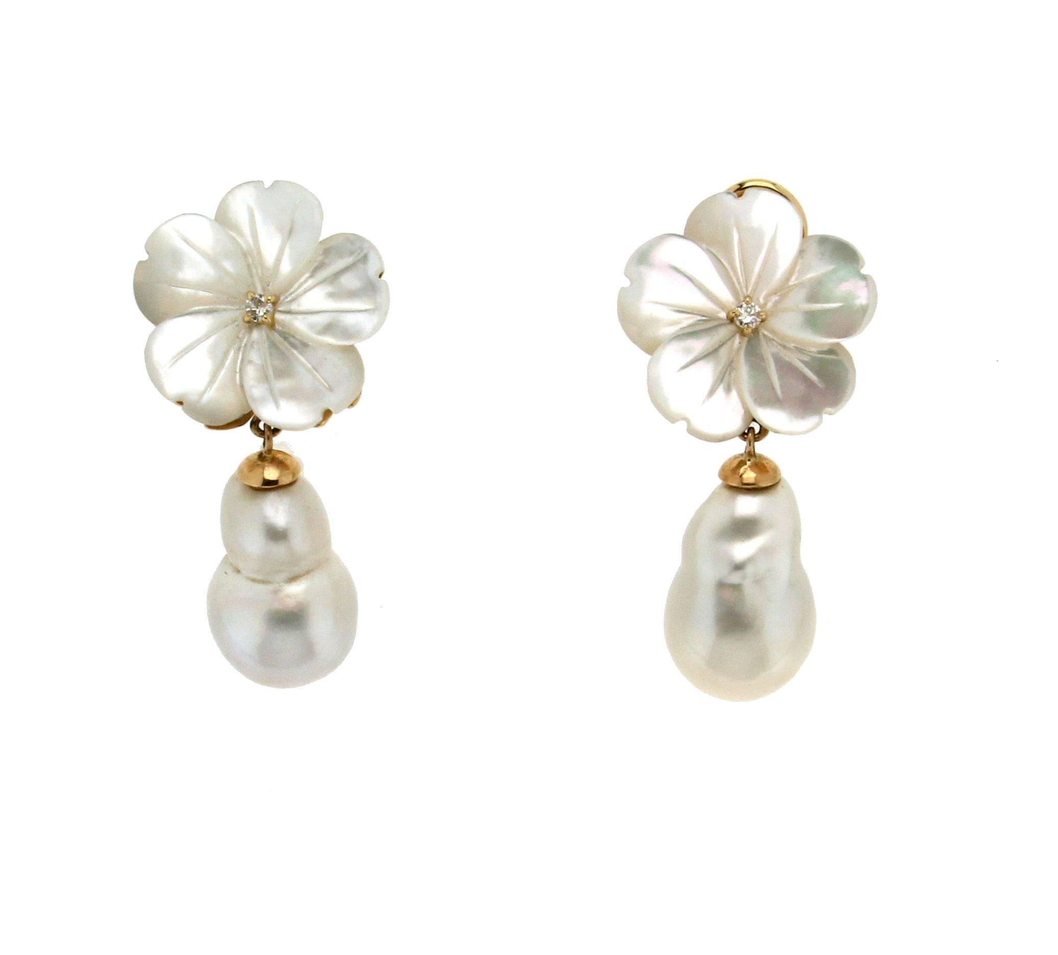 This lovely pair of mother of pearl flower earrings features white diamonds center,
The earrings are completed in 18kt yellow gold with clip backs and two pearl baroque drop.
Diamonds weight 0.10 kt
Pearls baroque weight 7 gr.