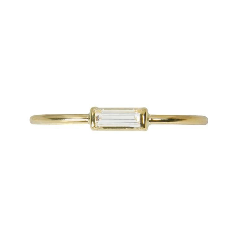 This 18k yellow gold band ring has a 0.15carat white diamond baguette and is the perfect modern take on a classic diamond solitaire ring. The diamond baguette is set neatly on a 1mm polished finished band. This ring ia a UK ring size L however it