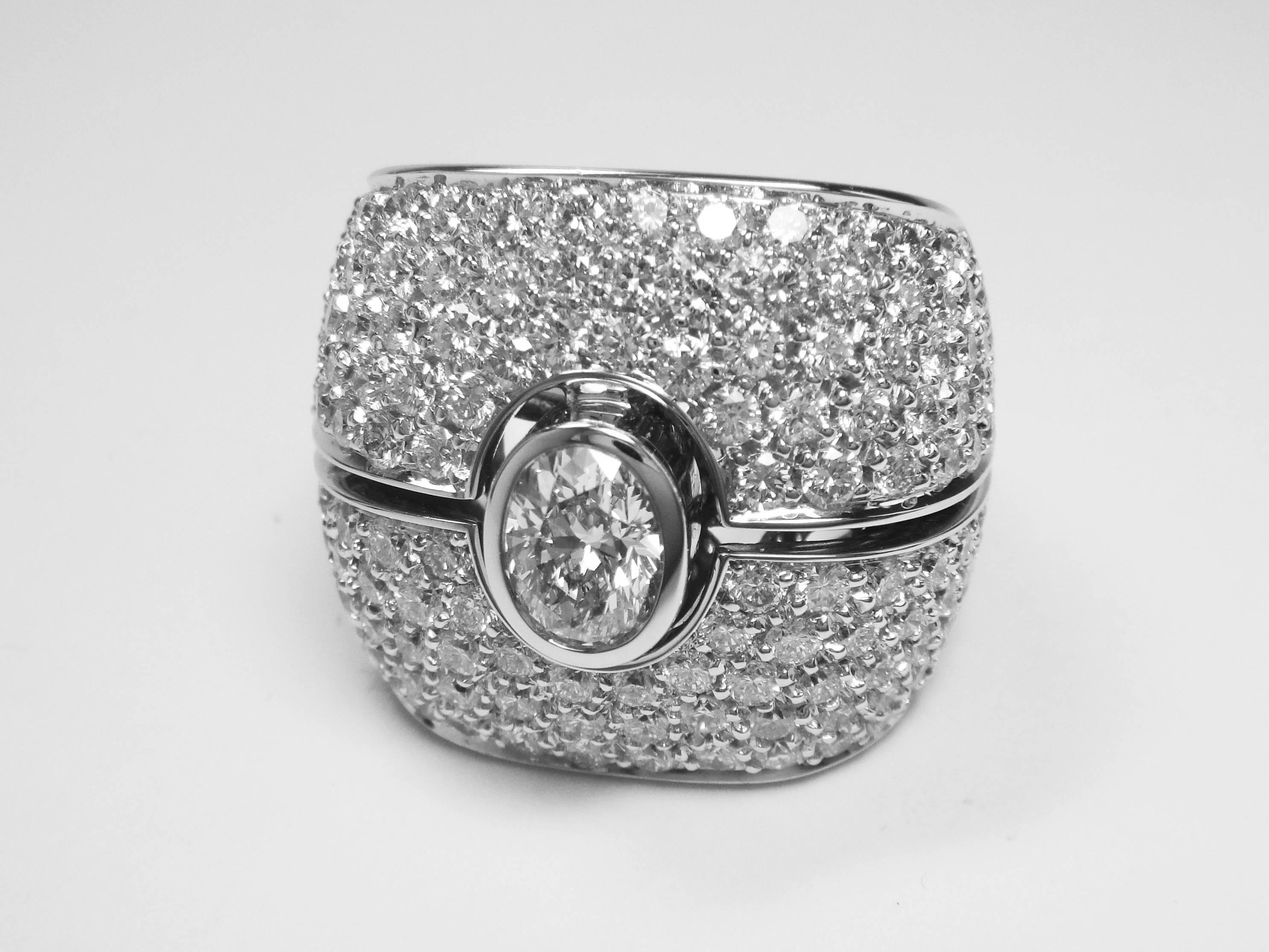 This ring is oval-shaped and exhibits 4.13 carats total weight of dazzling pavé setting diamonds, and a central oval shape diamond with 0.90 carat, all mounted on white gold. For its oval shape in an XL size this is certainly a statement piece.
This