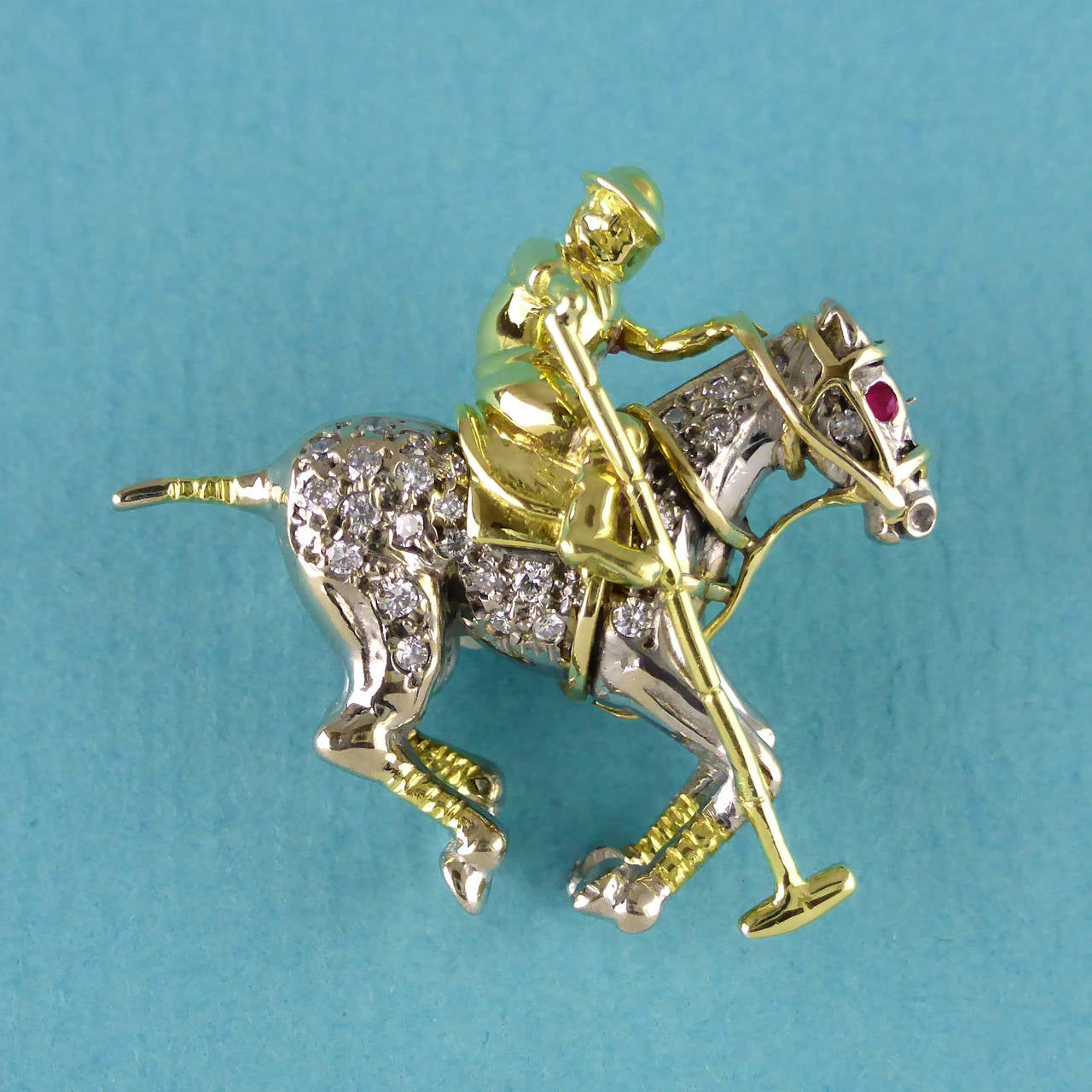 An 18ct white and yellow gold polo player mounted on horseback, set with diamonds and with a ruby eye.

Polo player in 18ct yellow gold mounted on an 18ct white gold horse, set with white diamonds and with a charming, beady, ruby eye. Hand made and