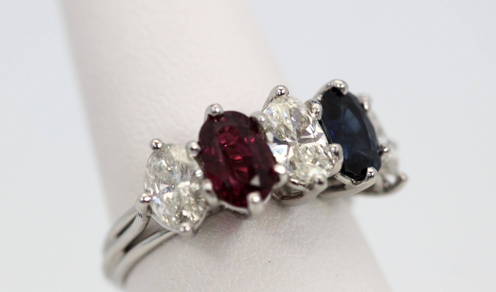 Five stone ring consists of 3 oval shape Diamonds, one oval shaped Ruby and one oval shaped Sapphire.  The Diamonds have an estimated weight of 1.39 carats, with a clarity grade of I1 and color grade G-H.  The Ruby has a color grade of purplish Red