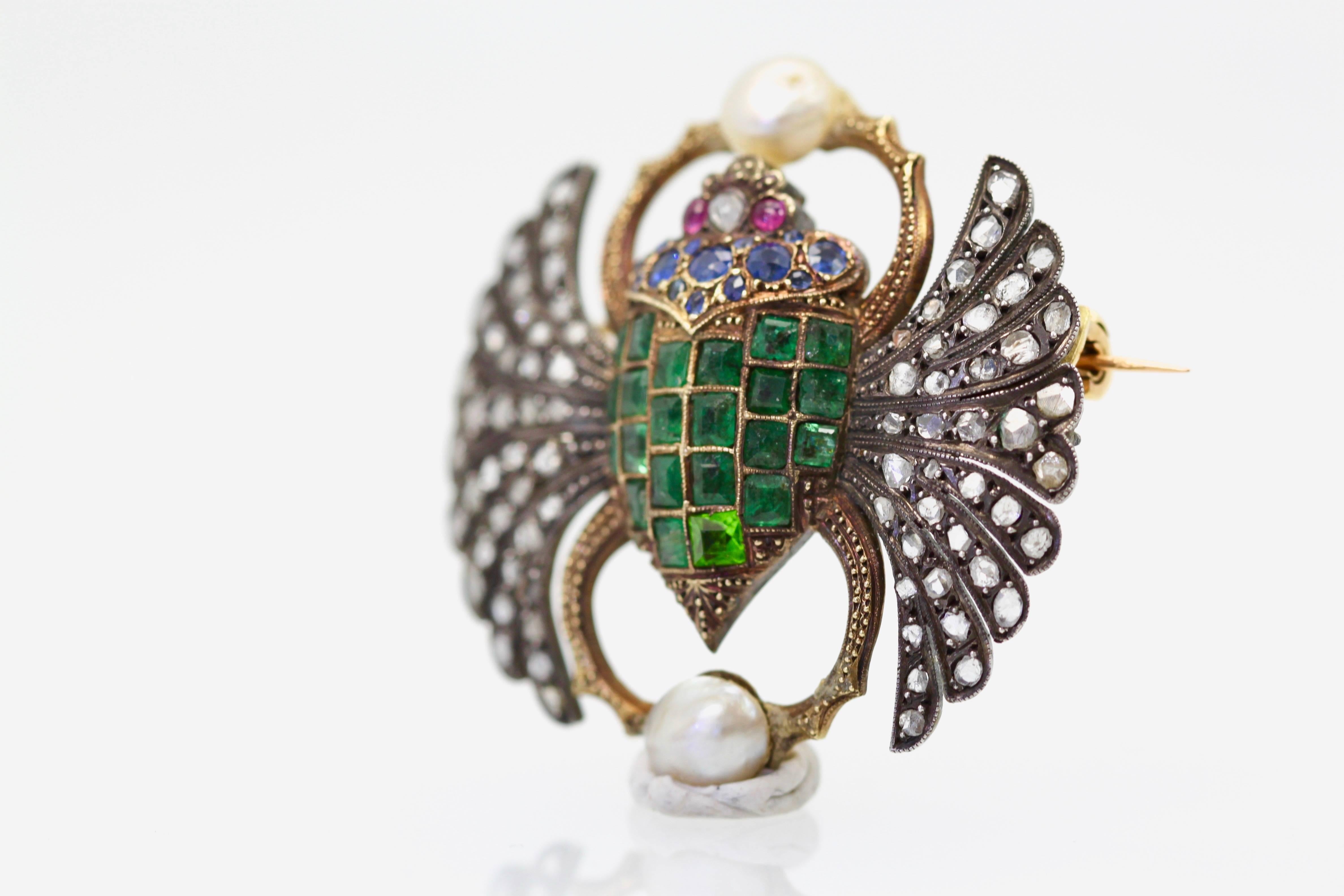 This unusual and highly coveted scarab brooch is set with Emeralds, Sapphires, Rubies, and Freshwater Pearls.  The wings are studded with Diamonds.  This piece is from France where during the turn of the Century until 1930 scarabs were very popular.