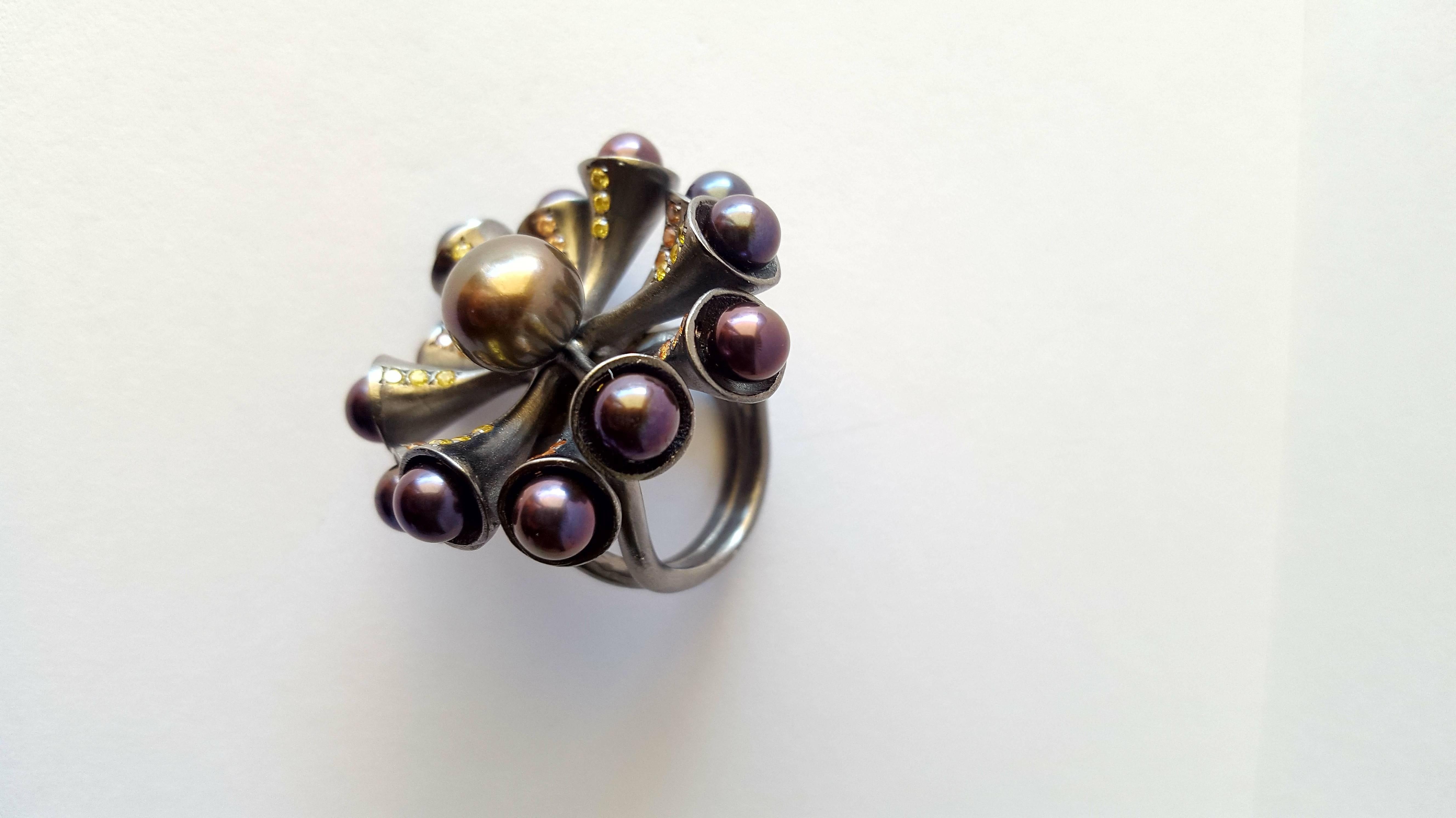 Statement ,black Rhodium plated, sterling silver ring with fresh water pearls , yellow and orange Zircons. Eye catching and dramatic this ring will transform any outfit. Fashionable, comfortable and easy to wear despite its size. The design is