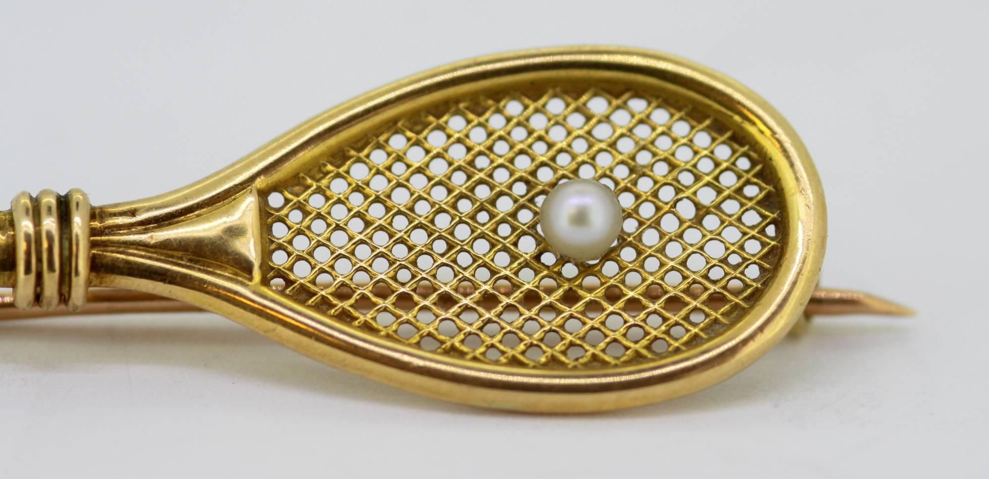 Vintage 18k yellow gold tennis racket brooch with freshwater pearl (0.10 ct) 
c.1980's
Fully hallmarked.

Approx Dimensions - 
Size : 5.3 x 1.4 x 0.6 cm
Weight : 2 grams

Freshwater Pearl -
Size : 0.10 CT

Condition: Has signs of general usage, no