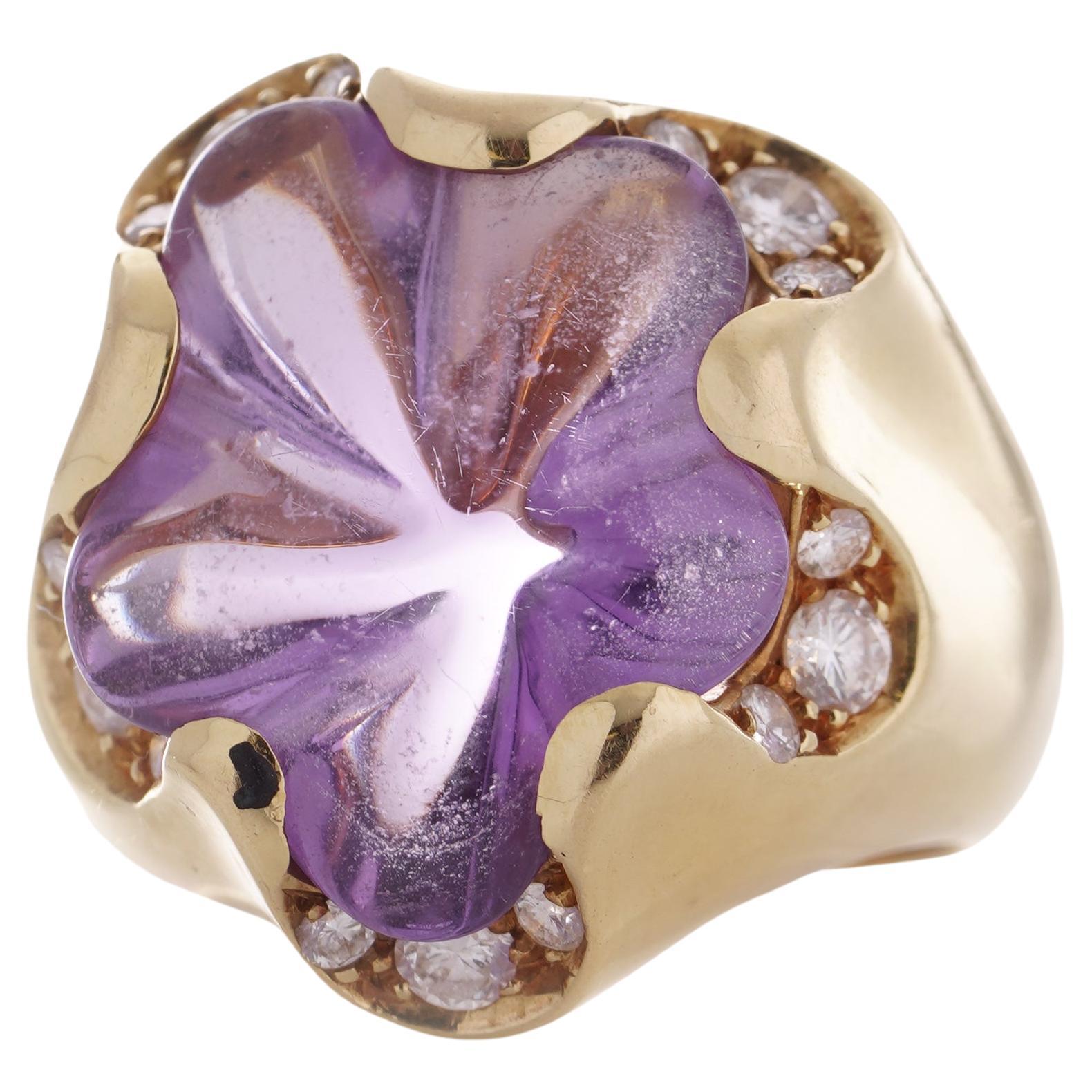 Fred of Paris 18kt. yellow gold Amethyst and diamond ring.

This ring features a floral-shaped amethyst, securely set within a polished bezel, accompanied by fifteen brilliant round-cut diamonds delicately bead-set onto the petals. The amethyst
