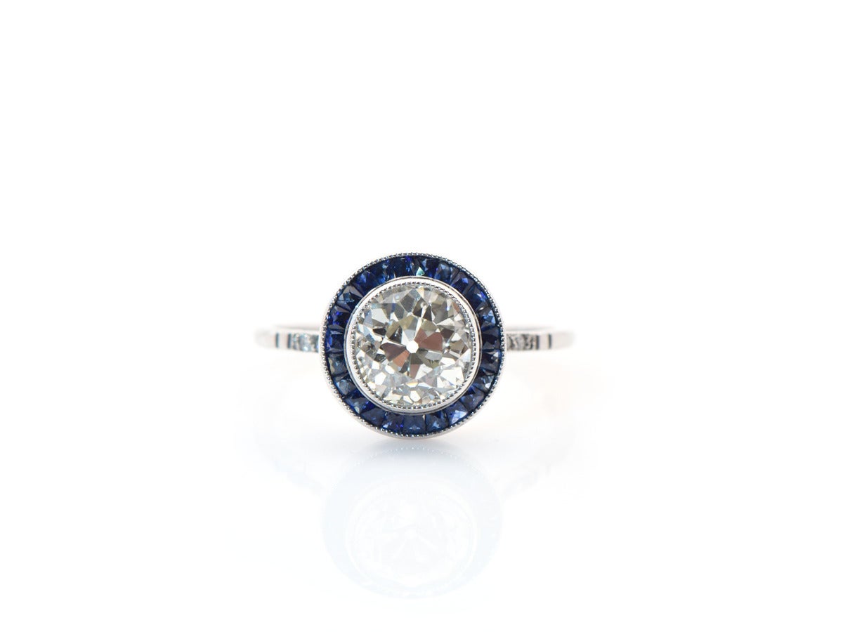 A bezel set 1.61ct antique European diamond with a french cut sapphire border set in platinum.  Size 7