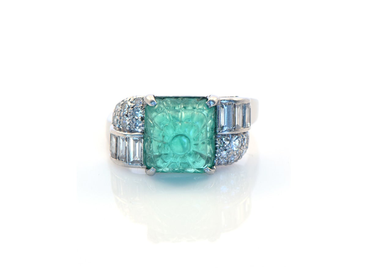 Approximately 3ct carved emerald cushion cabochon with baguette and single cut diamonds, set into platinum. Ring size 8.