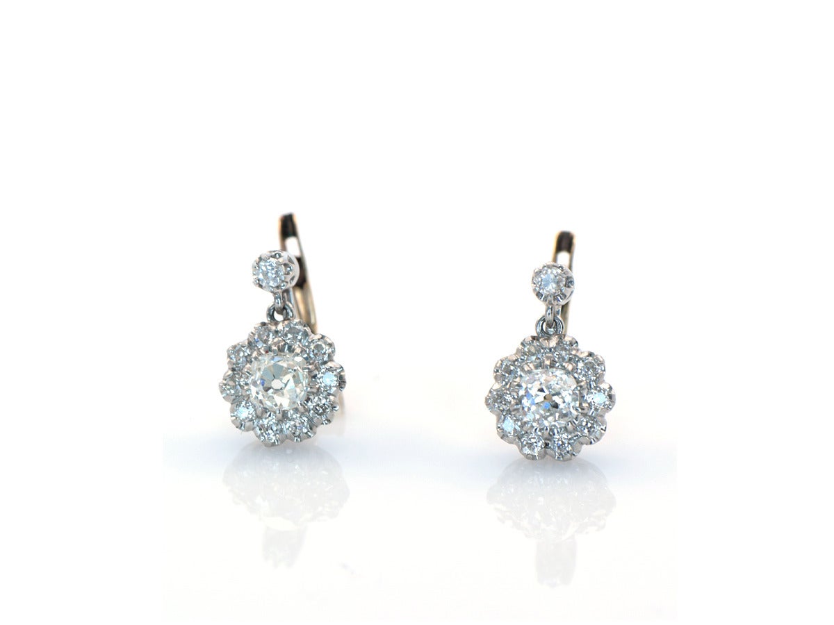 Platinum and 14k gold earrings setting old mine cut diamonds into cluster drops.