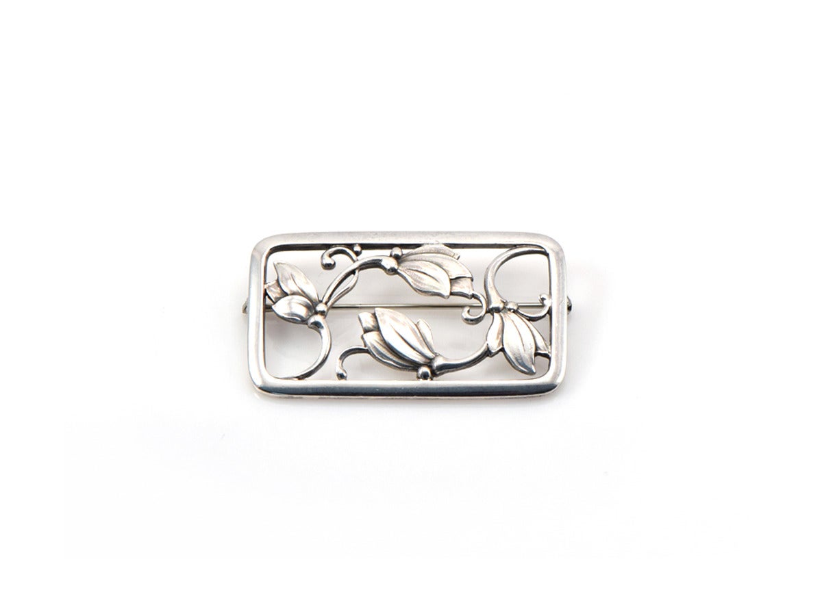 An authentic Georg Jensen pin in sterling silver, featuring an openwork flower motif.