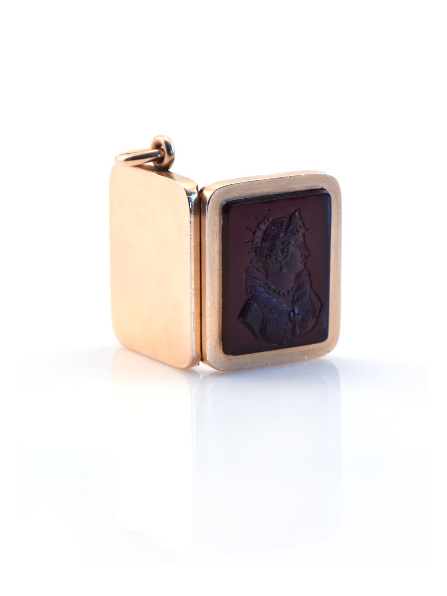A billfold style 14kt gold locket with an intaglio of a carved onyx Empress Lady.
