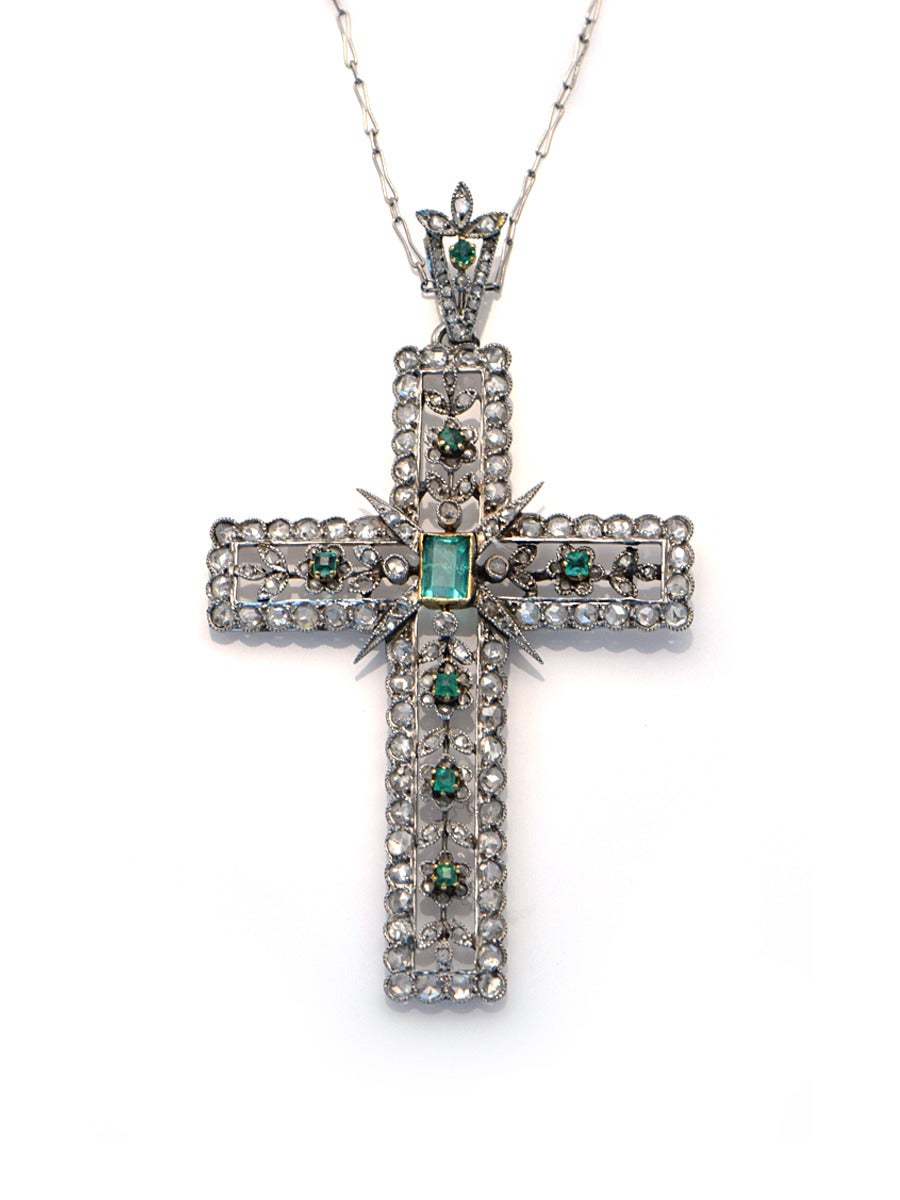 This platinum cross is fully fabricated, using old world techniques. The open work of the cross is accentuated with rose cut diamonds.  Emerald cut emeralds highlight areas and add a bright pop of color. 

*Chain is 17