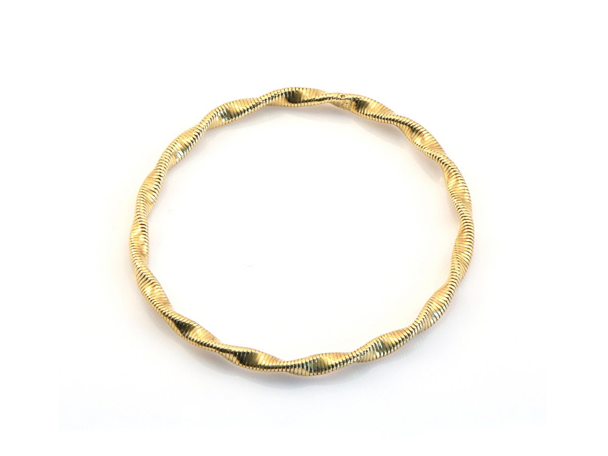 A Tiffany & Co. bangle bracelet in 18kt gold.  The design has a modern appeal with a retro throwback. 

*18kt and solid
*5mm thick
*inside diameter is 2.5 inches
*stamped Tiffany & Co. on the inside