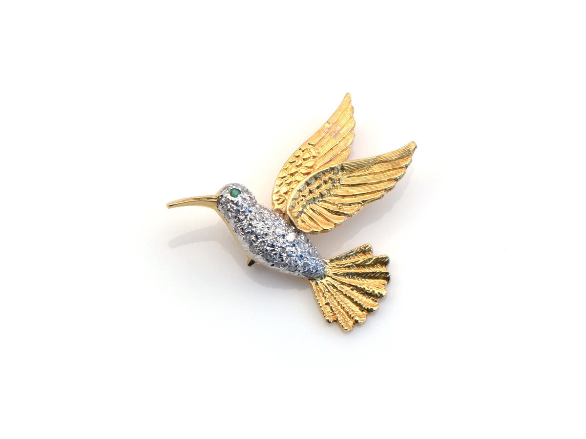 A sweet little hummingbird with golden wings of flight and a diamond pave encrusted body.

*18kt gold 
*Emerald eye
*Single cut diamonds
*Approximately .25ct diamond