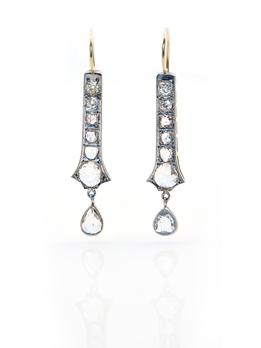 An EXCEPTIONAL pair of Russian rose cut diamond earrings.  The individual rose cut diamonds are bead set into sterling silver and 18k yellow gold, with bright cut engraving along the edges. Milligrain finishes off the taper of the diamond drop
