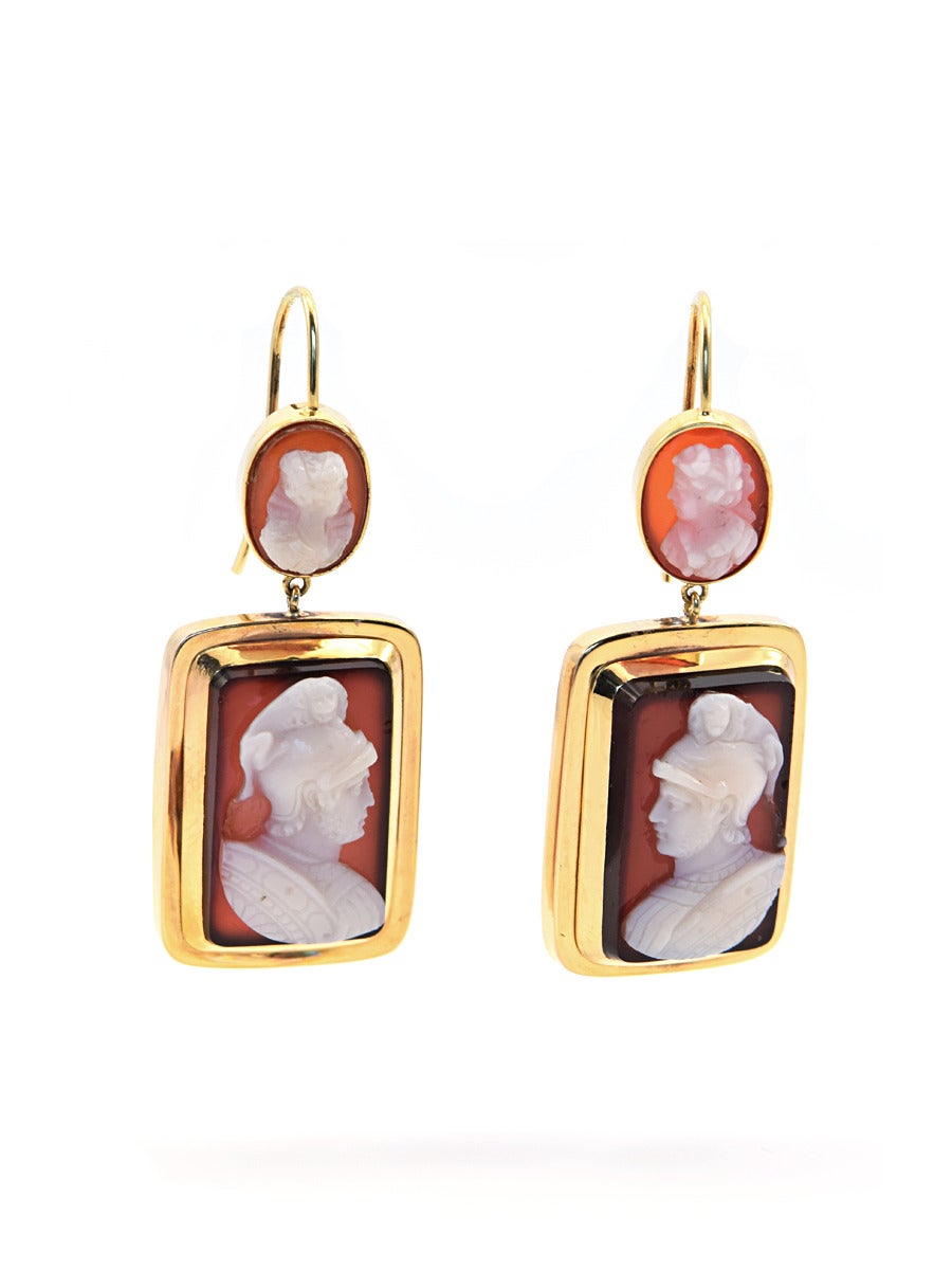 An interesting pair of carved gladiator cameo earrings, in 14k gold. The top carved cameo is of a maiden and the bottom is of her hero, the gladiator.