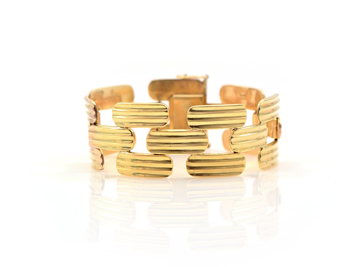 A bold and remarkable gold bracelet! The bracelet links lie flat to the wrist and hinges at the end of the center sections. 

*width is 1