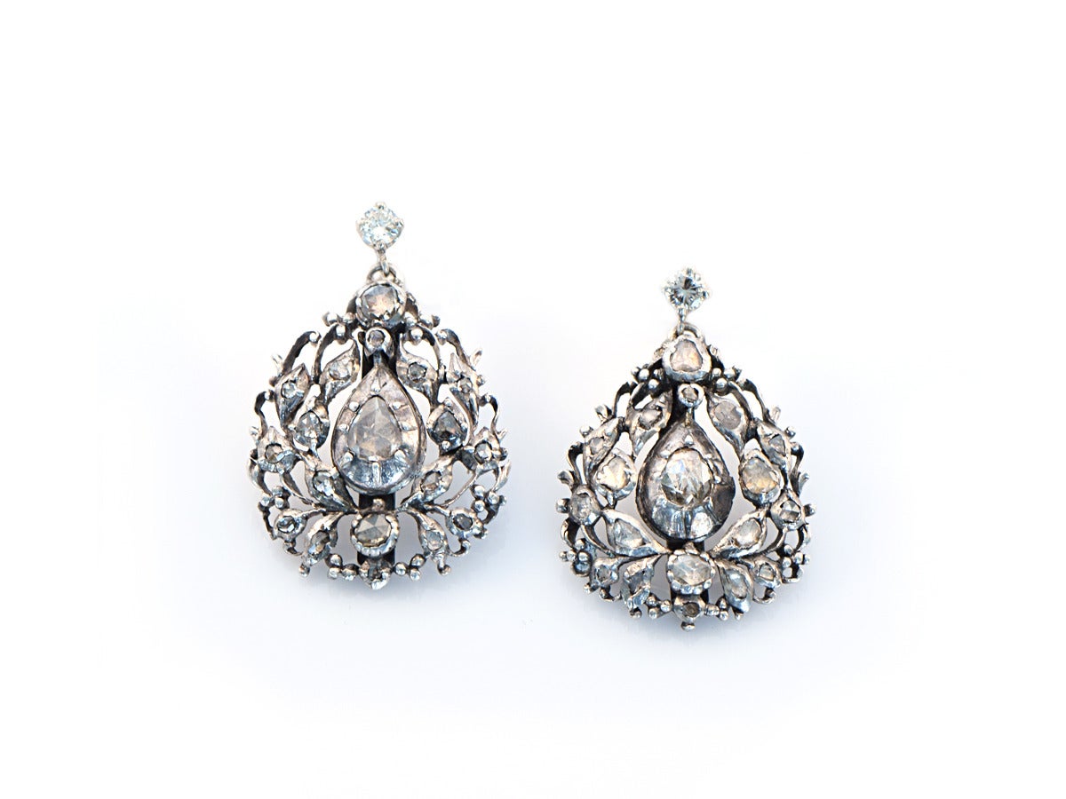These French-made garland style earrings were created in sterling silver and set an assortment of rose cut diamonds.  The top studs are made in 14k white gold and set modern cut diamonds which are *not* original to the earrings.

The earrings are